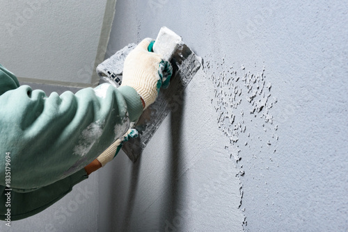 Applying concrete pebble plaster kornik using putty knife.