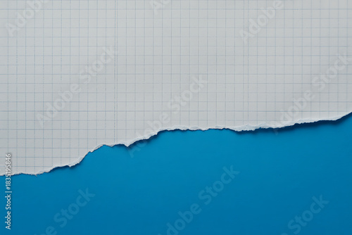 Torn piece of white lined paper revealing a vibrant blue background, creating a dynamic contrast