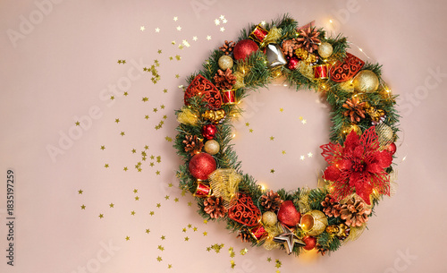 Christmas advent wreath with red and golden ornaments on a beige background. Marry Christmas greeting card.