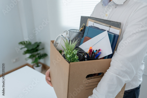 Stressful businessmen will resign from the company. lifting a brown paper box that holds personal items. resignation, job placement and vacancies concept.