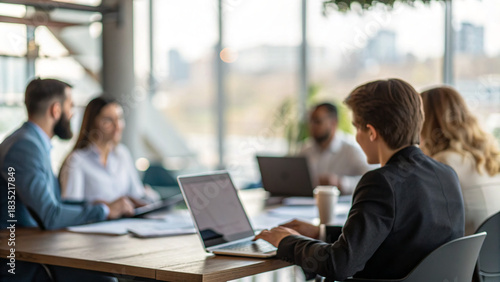 Wallpaper Mural Group of people meeting in a modern office space discussing ideas while working on laptops at midday Torontodigital.ca