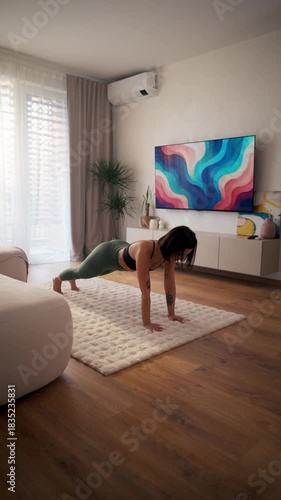 woman engaging in core strengthening plank exercise in sunlit living space with art and plant