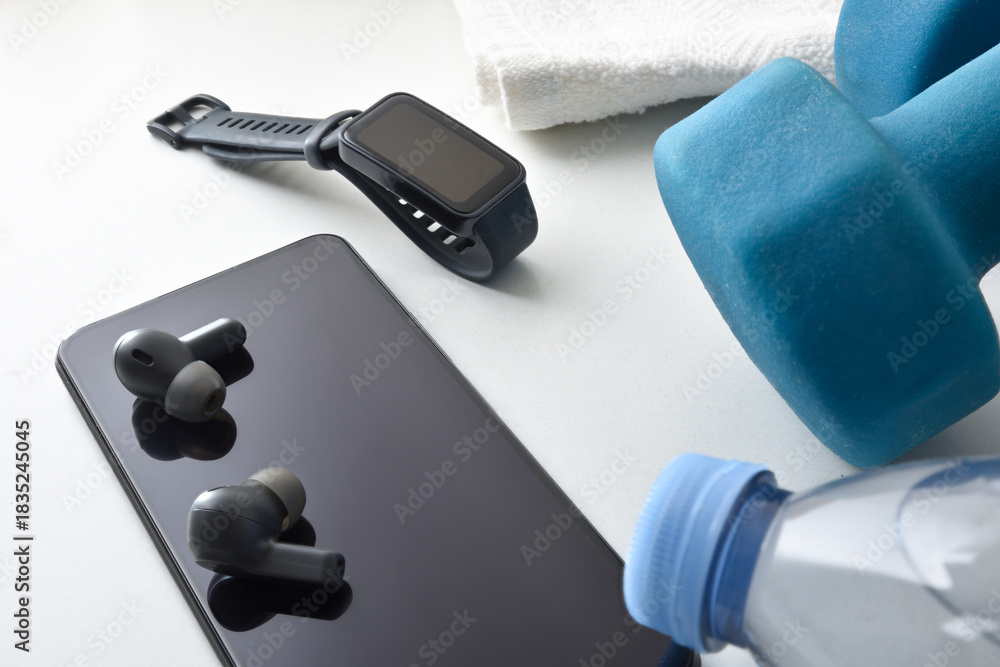 Fototapeta premium Wearable devices for sports with sports equipment on white table