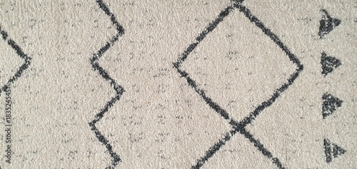 The texture of a white carpet with a pattern of simple black broken and intersecting lines. Carpets for home decor, wallpaper, textiles, and fashion.