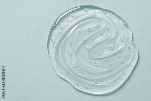 Clear cosmetic gel smear texture on blue background AI generated