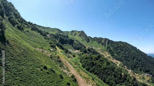 Panorama of mountain landscape: steep mountains covered with forest form deep gorge, along the mountainside there is awinding road with sharp turns - mountain serpentine.