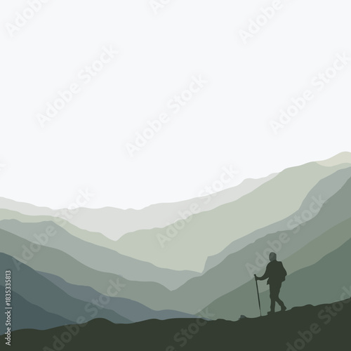 Hiker standing on mountain ridge against misty green landscape  