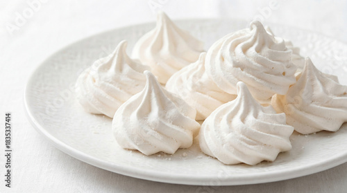 Sweet and Delicate Meringue Cookies on a White Plate. Cloud Dancer color of 2026 year. 
