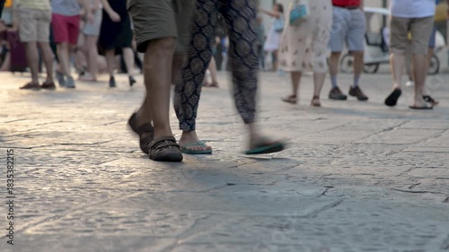 People walking in downtown across paved square, low angle shot