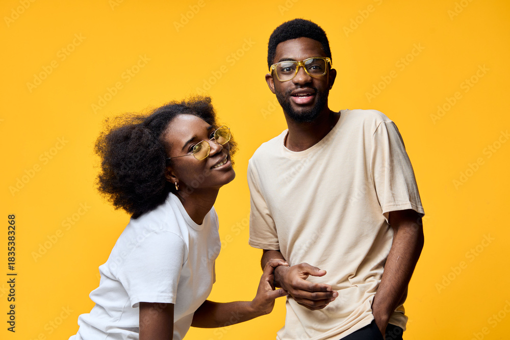 Obraz premium Happy couple wearing stylish glasses, bright yellow background, showcasing joy and connection, perfect for lifestyle and fashion concepts