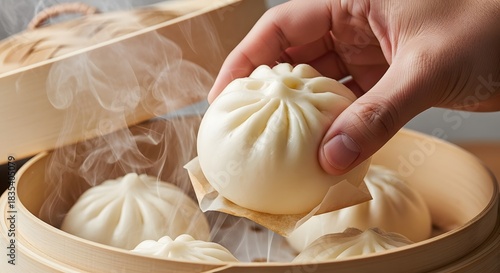 Hand picking up a hot, steaming baozi from a traditional bamboo steamer for authentic asian food concept and delicious culinary experience