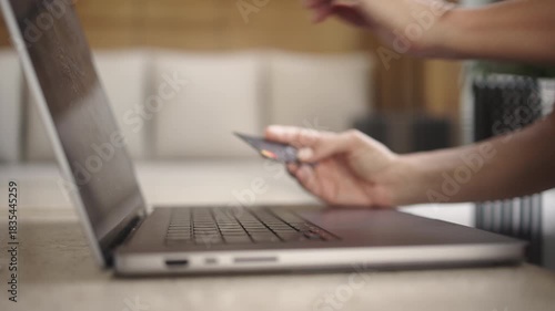 Close-up of female hands entering card details on a laptop, followed by cash banknotes appearing. Concept of online payments, e-commerce, digital transactions and credit.