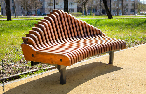 Wooden modern bench in the park. Landscape design
