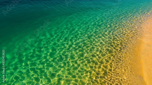 Crystal clear turquoise water meets golden sand beach with sunlit ripple patterns