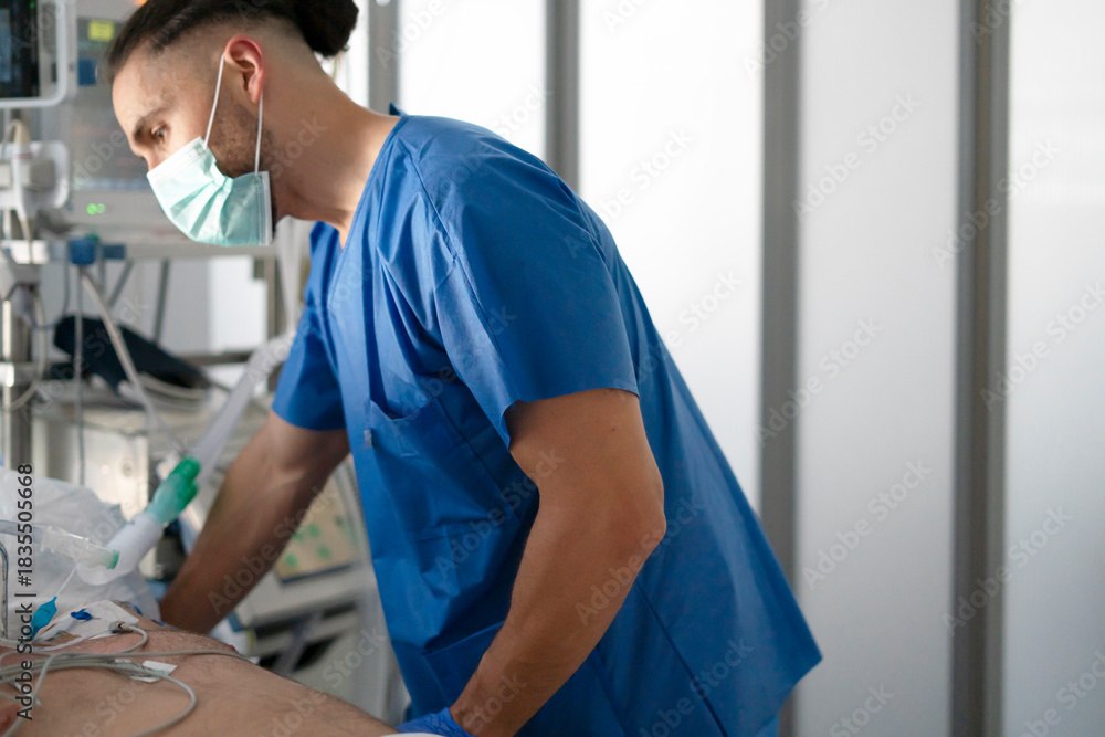 Fototapeta premium Male nurse caring for patient in icu