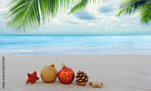 Christmas background with colorful decorations on Caribbean beach.