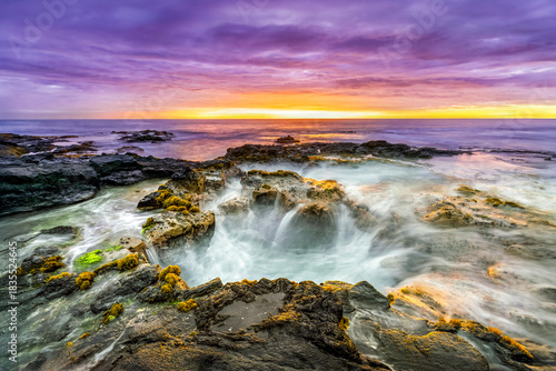 Pele’s Well is a blow hole lava tube on the rocky beach  on the Big Island of Hawaii. One end is open to the sea and water rises, falls, and splashes with incoming waves of the Pacific Ocean.