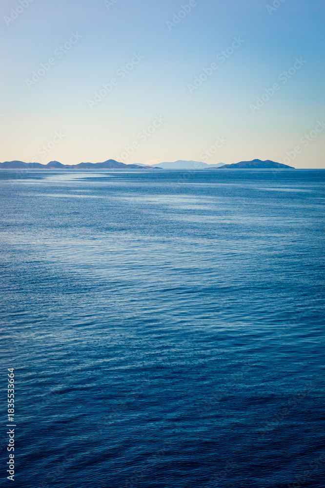 Obraz premium Beautiful calm Aegean Sea with islands of the Cyclades on the horizon.