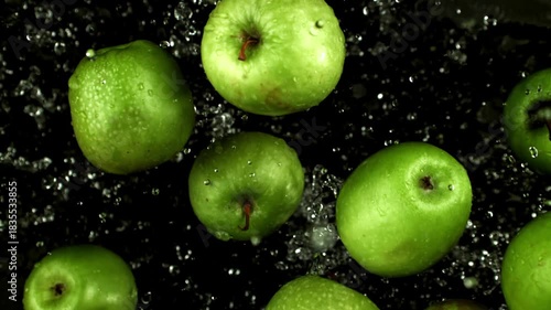 wet green apples arranged on black background with fine water droplets and rich glossy skin, cinematic Filmed on a high-speed camera at 1000 fps. High quality FullHD footage.