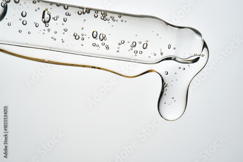 Cosmetic pipette dispensing serum with bubbles macro