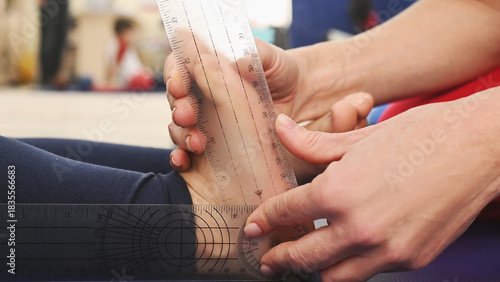 Fotografie A doctor measures a preschooler's flat feet using a goniometer