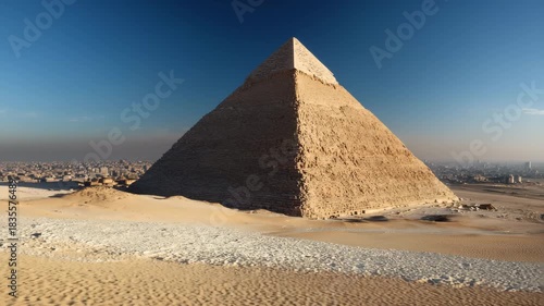 Ultra HD Closeup view of the pyramid of khafre in giza desert with cairo city skyline visible in the hazy background under a clear blue sky video