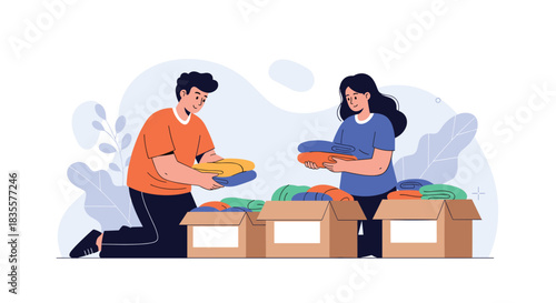 Young man and woman volunteering to sort and pack donated clothes into cardboard boxes for a charity organization or event.