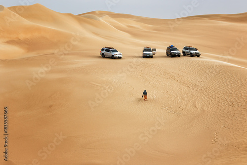 In the Siwa Oasis desert in Egypt, four off-road vehicles stand on golden dunes.