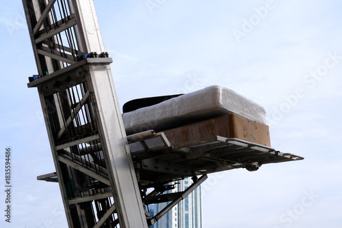 House moving with elevators. Lifting beds, paintings, refrigerators, coffee tables, and other packaged items. Movers loading items onto trucks. Tenants, homeowners. House rents. Housing prices.