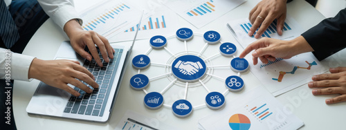 A professional team collaborates during a business meeting, analyzing data charts and utilizing laptops to strategize and discuss key insights for project success. Amity 