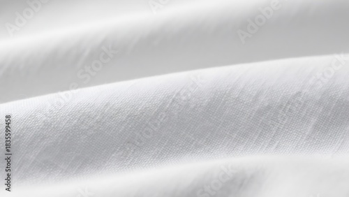 Close-up of white fabric surface showing wavy texture. Soft cotton textile material background for clothing, bedding, and interior design.