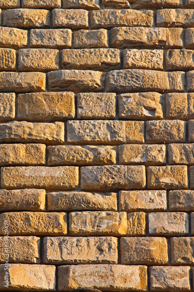 Naklejka premium Medieval Yellow Stone Brick Wall Background in Florence Tuscany Italy
