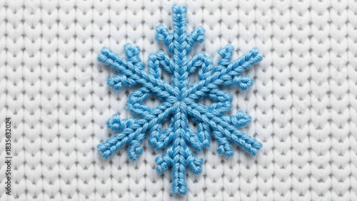 Adorable blue snowflake on cozy white knitted fabric evokes winter's charm, perfect for holiday crafts, seasonal designs, and warm festive greetings