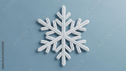 Elegant knitted snowflake creating a cozy winter mood on cool blue background, perfect for holiday crafts, seasonal designs, and festive promotions