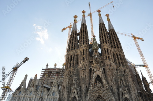A striking view of the Sagrada Família under construction, capturing Gaudí’s towering facades and cranes rising against the clear Barcelona sky.
