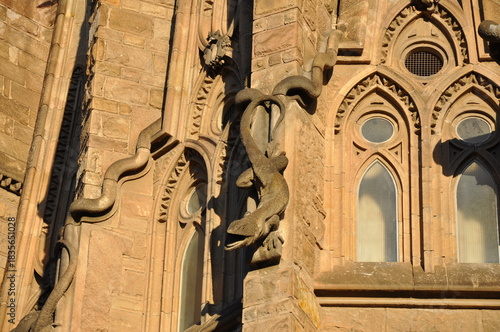 A detailed view of the Sagrada Família façade, featuring Gaudí’s signature organic curves and a sculpted salamander illuminated by warm afternoon light.