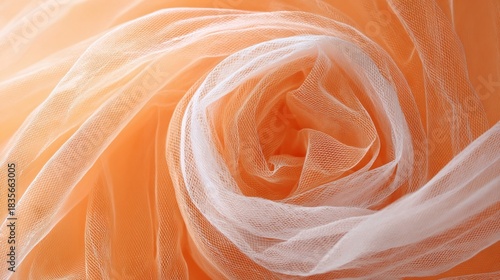 Swirl of delicate sheer fabric in pastel orange tones, center is paler