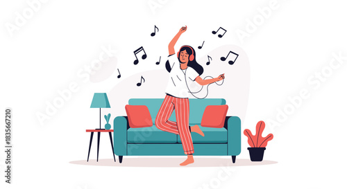 Happy young woman wearing headphones and dancing to her favorite music in the living room, enjoying a moment of pure joy at home.