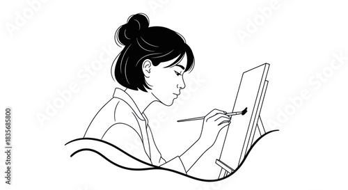 Young woman artist painting on canvas with brush in studio.