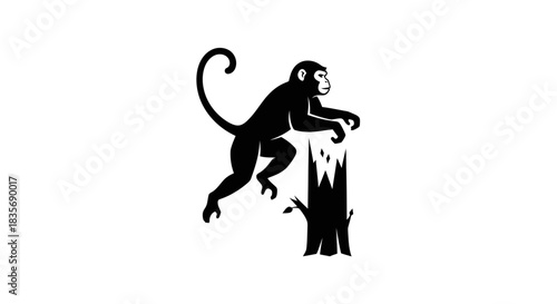 Black silhouette of a playful monkey jumping on a broken tree stump.