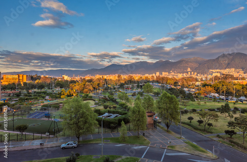 Sunset light over Bogota city park with Andean mountains skyline and dramatic golden evening clouds