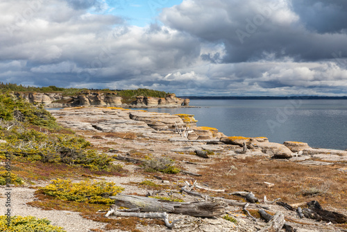 Colorful Limestone Cliffs and Rocky Shoreline of Petite Ile au Marteau Island near Havre Saint Pierre, Quebec, Canada on a Cloudy Autumn Day