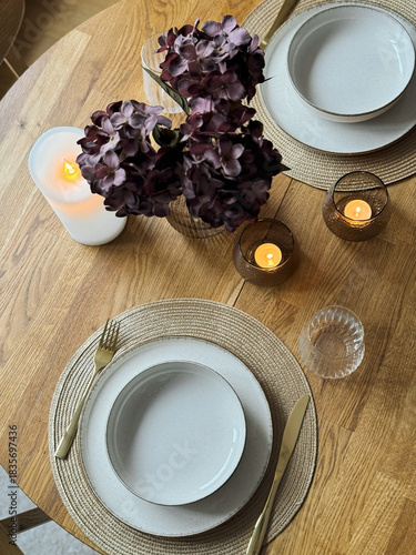 Foto Wooden round table setting with glassware and vase creating a stylish evening at