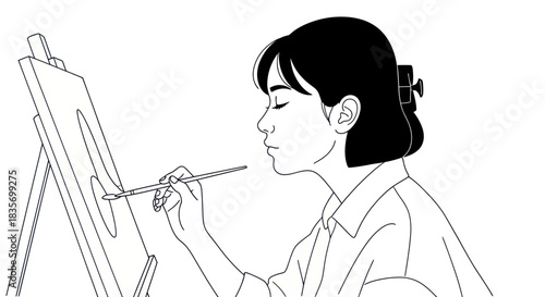 Artist at Work: A Focused Woman Painting on Canvas.