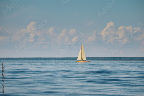 The lonely old wooden sailboat at sunny day, calm water, sailing regatta in the Gulf of Finland, sailing yacht competing in a race, splashing water, board the boat
