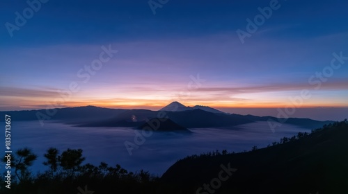 Dramatic sunrise over mountain range with mist and vibrant colors