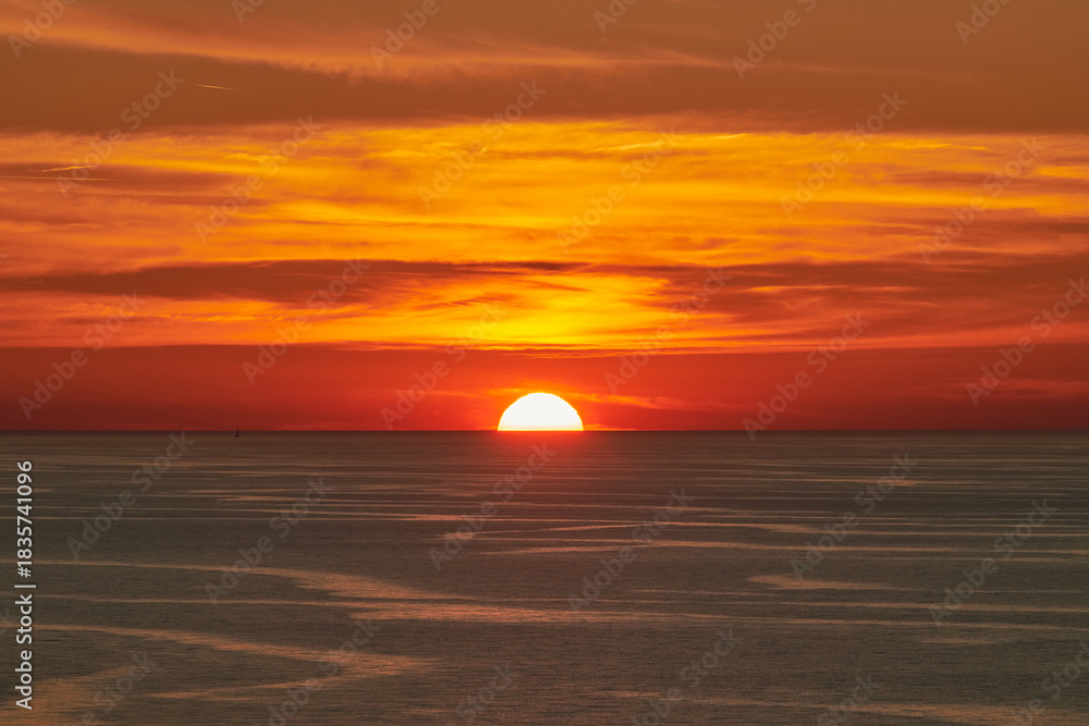 Obraz premium Glowing Sun Setting over Calm Sea