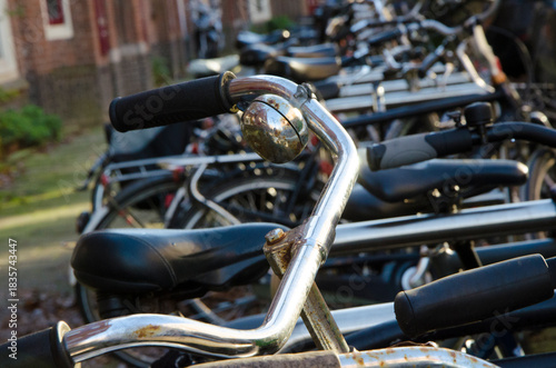 Fototapeta Naklejka Na Ścianę i Meble -  Bicycle parking near residential buildings on a small street in the center of old Amsterdam. North Holland, Netherlands.