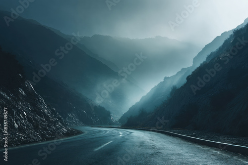 Winding mountain road disappearing into foggy atmospheric light