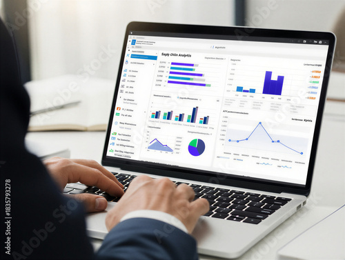 Close-up of a person in a suit typing on a laptop, displaying business intelligence dashboards and financial trading screens with charts, graphs, and complex data visualizations.